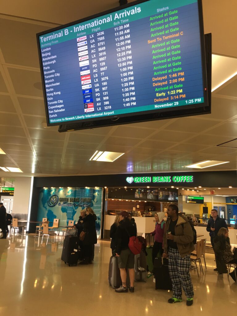 a large screen inside an airport terminal shows flight status